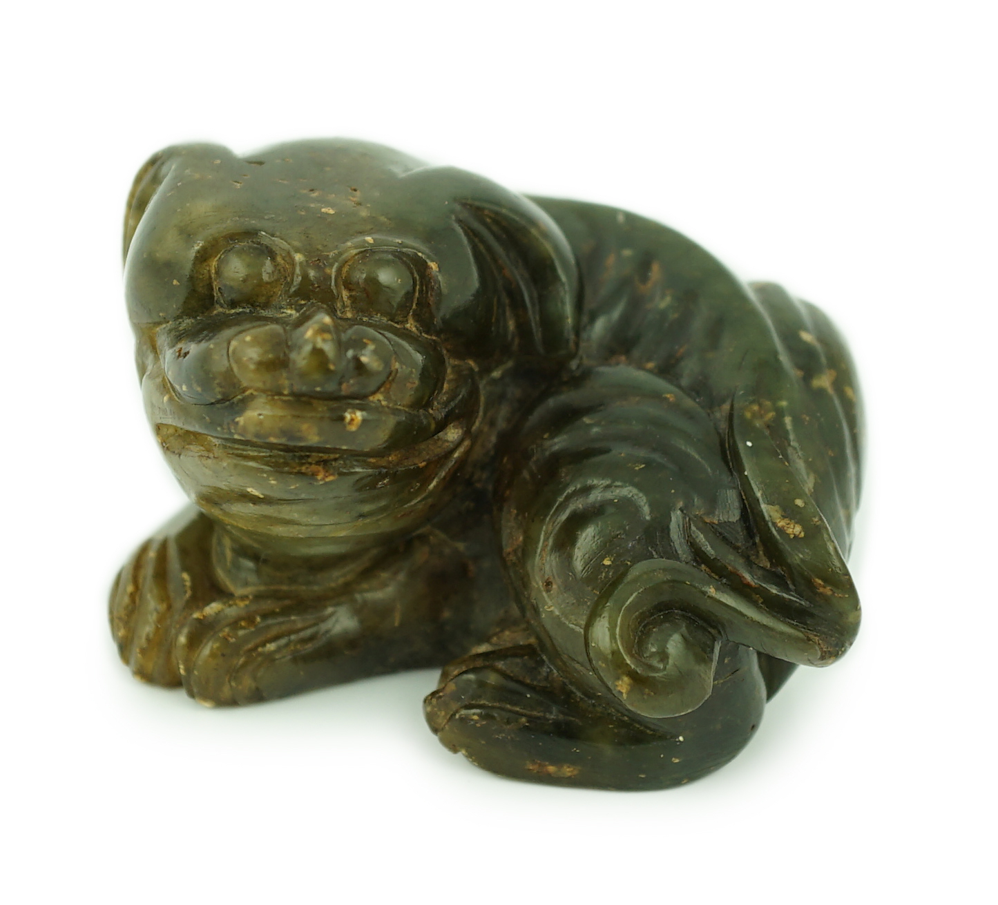 A Chinese Ming green soapstone figure of a recumbent lion-dog, 16th/17th century